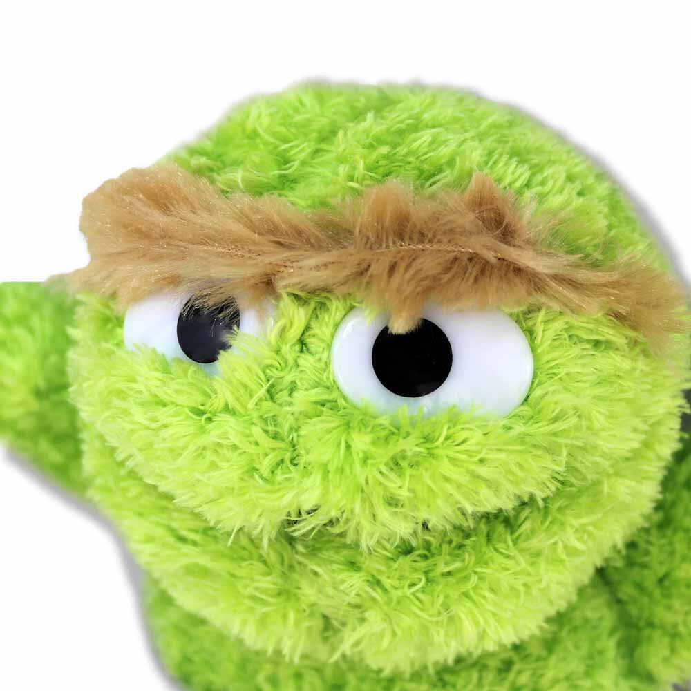 Detailansicht vom Kopf des Oscar Kuscheltiers mit grünem Fell und Kunststoffaugen, 38 cm groß